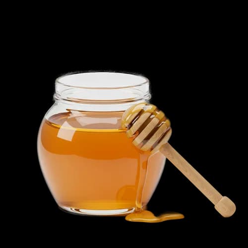 Glass jar of fresh golden honey with a wooden dipper